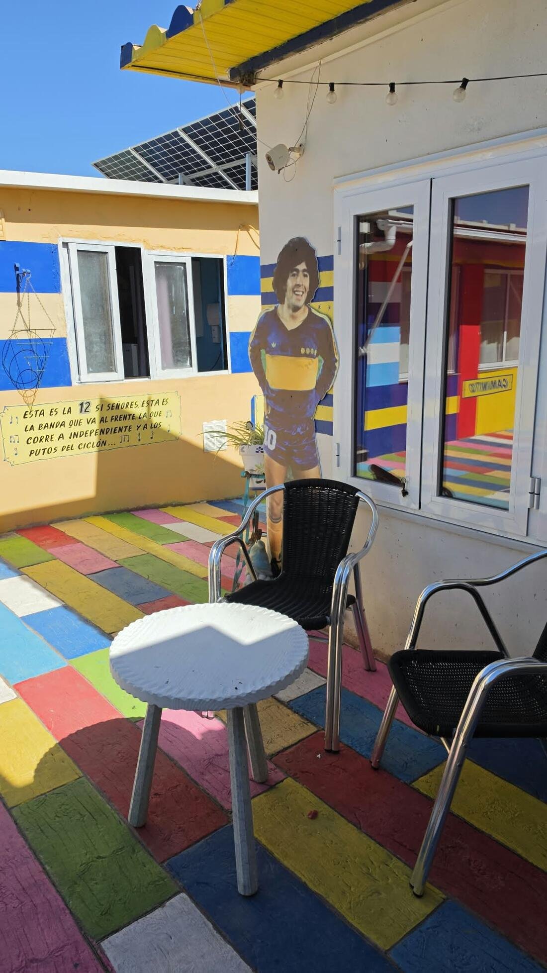 Patio de Casa Xeneize con mesa, sillas y suelo de colores